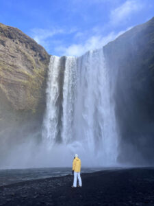 girl infront of skogafoss waterfall iceland